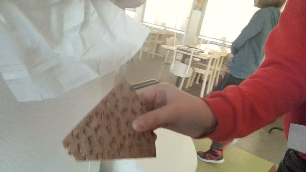 ett barn som håller i ett knäckebröd